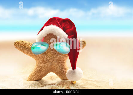 In rote Weihnachtsmütze Starfish am Meer. Weihnachten im Sommer Stockfoto