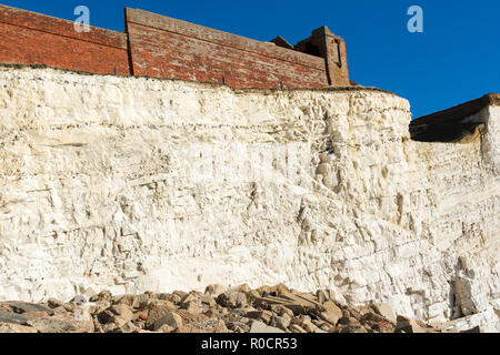 Zu Fuß zum Splash Punkt in Seaford East Sussex. England, Felsen, Meer und blauem Himmel, mit Blick auf die Überreste der Cliff Cottage oder Splash Point Hotel, selektiven Fokus Stockfoto