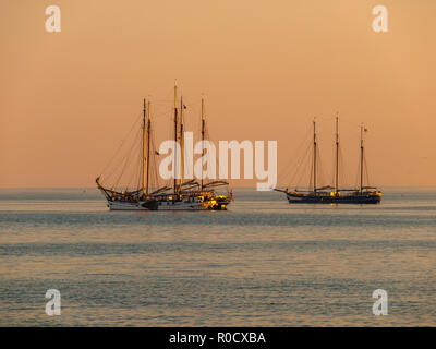 Vintage Segelschiffe in orangefarbenes Licht bei Sonnenuntergang über IJsselmeer, Niederlande Stockfoto