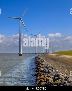 Lange Reihe von Windenergieanlagen im Wasser offshore positioniert an der Küste Stockfoto