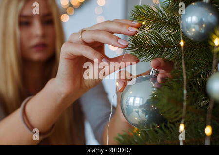 Junge Frau dekorieren Weihnachtsbaum Stockfoto