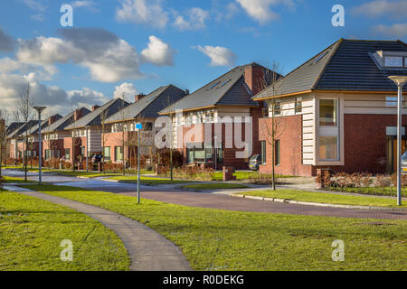 Freistehende holländische Familie Häuser entlang einer Vorstadtstraße im Winter, Groningen, Niederlande Stockfoto