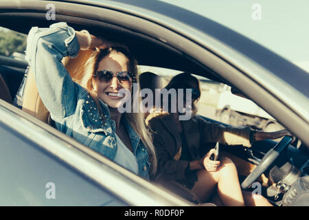 Getönten Foto von Seite der glücklichen Frauen im Auto sitzen Stockfoto