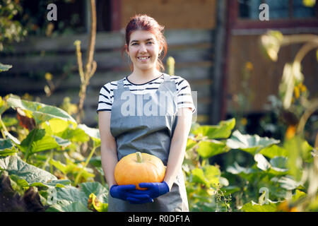 Bild der Frau mit Kürbis in die Hände am Garten Stockfoto