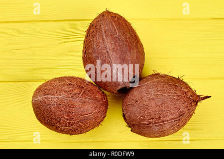 Drei Kokosnüsse auf Holz- Hintergrund. Stockfoto