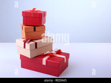 Ein Haufen von Weihnachtsgeschenke in bunten Verpackung mit Bändern auf einem schönen Parkettboden mit Copyspace Stockfoto