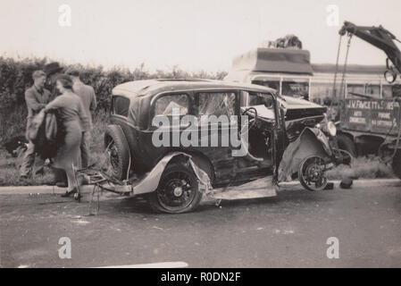 Jahrgang 1930 Foto, ein stark beschädigtes Auto aus der Szene von einem Verkehrsunfall eingezogen werden. Recovery Truck von J. W. Fawcett & Sons Ltd von Catterick. Stockfoto