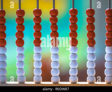 Abacus mit roten und weißen Perlen mit einem lebhaften farbigen Hintergrund Stockfoto