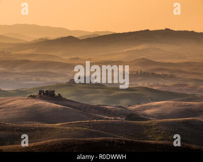 Sonnenaufgang über Betriebe in die hügelige Landschaft in der Toskana, Italien Stockfoto