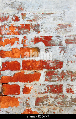 Alte Mauer aus rotem Backstein teilweise durch Zement bedeckt gemischt mit Kalk Stockfoto