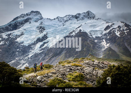 Zwei Bergsteiger mit dem Kopf nach oben Der Weg in die Berge im Nationalpark am Mt Cook, Neuseeland Stockfoto