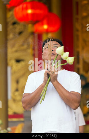 Die Stadt Phuket, Thailand, Oktober 05, 2016: ein Mann betet, holding Lotus Blumen und Räucherstäbchen in der sapha Hin Schrein von Phuket Town, Thailand Stockfoto