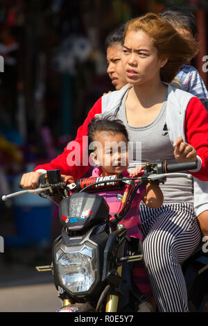 THONG PHA PHUM, Thailand, 23. JANUAR 2016: drei Erwachsene und ein Kind reiten einen Roller, ohne Helm Schutz in der Straße von Thong Pha Phum, Stockfoto