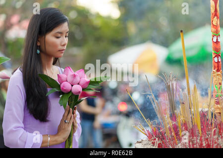 Vietnamesisches Mädchen im Buddhistischen Tempel beten, holding Lotus Blumen, Saigon, Vietnam Stockfoto