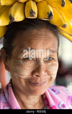 MANDALAY, Myanmar, 22. JANUAR 2015: Portrait eines lustigen burmesischen Frau trug eine Banane Bündel auf dem Kopf, im langsamen Boot von Mandalay nach Bagan in Stockfoto