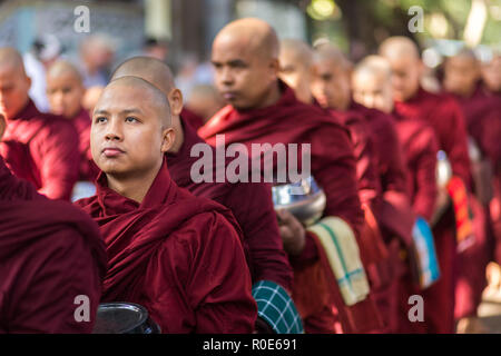 AMARAPURA, Myanmar, Januar 20, 2015: Junge Mönche sind queuing Holding ihren Schüsseln die einmalige tägliche Mahlzeit am Mittag in der mahagandayon Monas sammeln Stockfoto