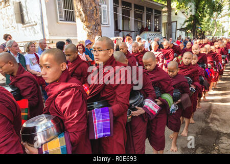 AMARAPURA, Myanmar, Januar 20, 2015: Junge Mönche sind queuing Holding ihren Schüsseln die einmalige tägliche Mahlzeit am Mittag in der mahagandayon Monas sammeln Stockfoto