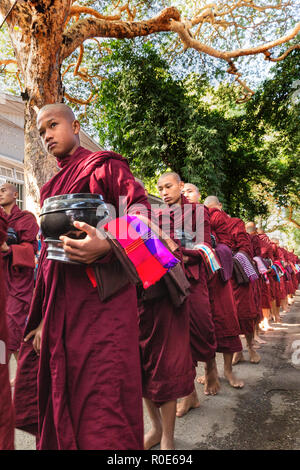 AMARAPURA, Myanmar, Januar 20, 2015: Junge Mönche sind queuing Holding ihren Schüsseln die einmalige tägliche Mahlzeit am Mittag in der mahagandayon monast sammeln Stockfoto