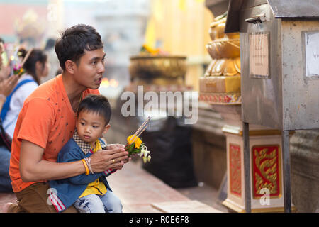 LAMPHUN THAILAND, Dezember 31, 2014: ein Mann und sein Sohn beten für das Neue Jahr außerhalb des buddhistischen Tempel von Wat Phra That Hariphunchai in Lam Stockfoto