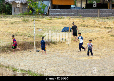 MAE KLANG Luang, Thailand, 31. Dezember 2014: Einige Kinder spielen Fußball-Fußball in einem trockenen geerntet Reis Feld im Dorf von Mae Klang Luang, Stockfoto