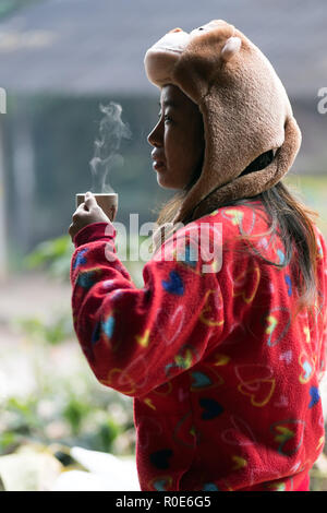 MAE KLANG Luang, Thailand, 31. Dezember 2014: eine thailändische Frau trinkt eine Tasse frischen organischen Kaffee von der Plantage im Dorf Mae Klang L Stockfoto