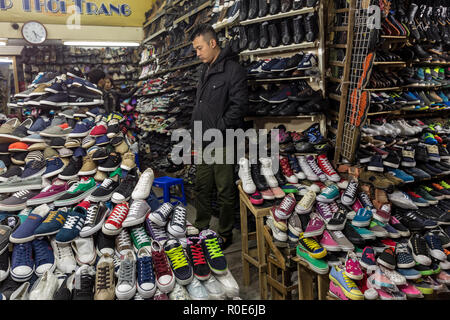 HANOI, VIETNAM, Dezember 15, 2014: Ein Unentschieden, der Mensch ist ein Blick in ein Geschäft in der Verkauf von Schuhen in Hanoi, Vietnam spezialisiert Stockfoto