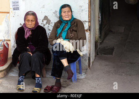 HANOI, Vietnam, 15 Dezember, 2014: Zwei alte Frauen sitzen auf der Straße beobachten, die das urbane Leben in Hanoi, Vietnam Stockfoto