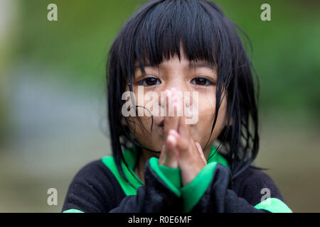 BANAUE, Philippinen, 04. Dezember: Ein junger unbekannter philippinischen Mädchen ist Beten unter dem Regen im Dorf von Banaue, North Luzon, Philippi Stockfoto