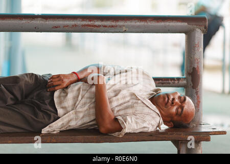 BANGKOK, THAILAND, 29. JULI 2013: Eine obdachlose reifer Mann schläft auf einer Bank in Bangkok, Thailand. Stockfoto