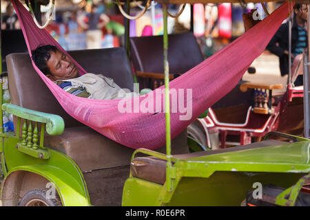 SIEM REAP, Kambodscha, 3. DEZEMBER 2012: ein Tuk-tuk Fahrer ist ein Nickerchen in einer Hängematte im Auto in Siem Reap, Kambodscha liegen Stockfoto