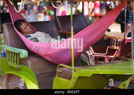 Siem Reap, Kambodscha, 3. Dezember 2012: ein Tuk-tuk Fahrer ist ein Nickerchen in einer Hängematte im Auto liegen in Siem Reap, Kambodscha Stockfoto