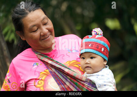 BAAN SUCHEN KAO LAM, Thailand, 20. November 2012: Unbekannter Mutter von einem Lahu Stamm ist Stolz präsentieren sein Baby im Dorf Ban Kao aussehen L Stockfoto