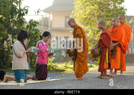 VANG Vieng, Laos, 19. MÄRZ 2011: Frauen, die täglich Essen an der buddhistischen Mönche während der frühen Morgen traditionellen Almosen in der Ortschaft Viang Vieng, L Stockfoto