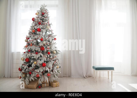 Weihnachten verschneite Weihnachtsbaum mit Geschenken in einem weißen Raum im Winter Stockfoto