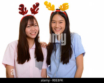 Zwei junge gerne asiatische Mädchen lächelnd bereit für Weihnachten Stockfoto