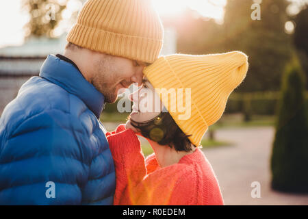 Romantische junge Paare sehen sich gegenseitig mit großer Liebe und haben schöne Beziehung, zu küssen, zu Fuß im Freien in Park, tragen Sie warme Kleidung. Reizend Stockfoto