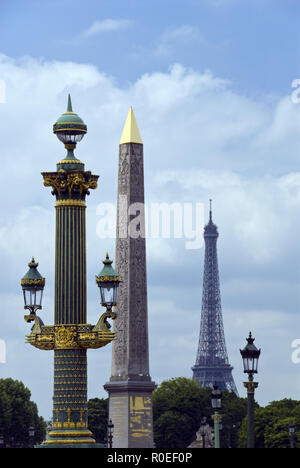 Der Eiffelturm (Tour Eiffel) über eine reich verzierte Laterne und der Ägyptische Obelisk, der in der Place de la Concorde, Paris, Frankreich steht. Stockfoto