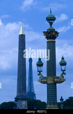 Der Eiffelturm (Tour Eiffel) über eine reich verzierte Laterne und der Ägyptische Obelisk, der in der Place de la Concorde, Paris, Frankreich steht. Stockfoto