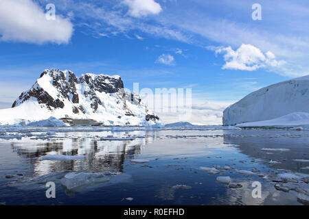 Eine Antarktisexpedition Kreuzfahrtschiff vor Anker inmitten glitzernde eisige, reflektierendes Wasser von Paradise Bay auf der Antarktischen Halbinsel an einem sonnigen Sommertag Stockfoto