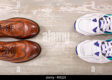 Männer aus braunem Leder Schuhe und Sneakers auf dem Fussboden. Männer braune Schuhe. Stockfoto