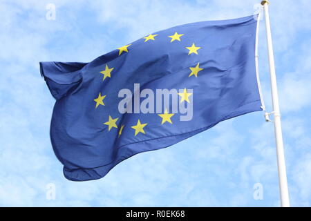 Nahaufnahme des einheitlichen europäischen Flagge mit zwölf gelben Sternen winken im Wind vor blauem Himmel Stockfoto