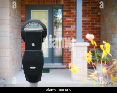 Vor dem Eingang des Hauses befindet sich eine Parkuhr. Dieses Bild ist an die Lebenshaltungskosten in Ihrem Haus. Stockfoto