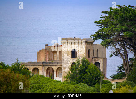 Ein altes verfallenes Schloss liegt hoch auf einem Hügel mit Blick auf das Meer Stockfoto