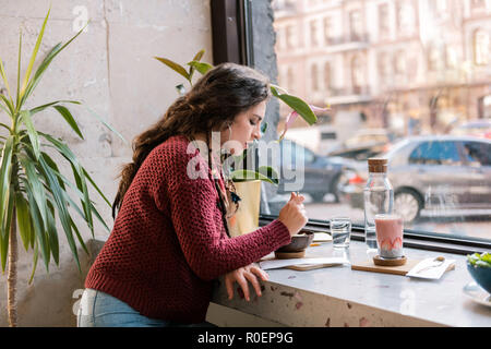 Schöne Frau genießen ihr Morgen beim leckeren Frühstück Stockfoto