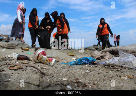 Lhokseumawe, Aceh, Indonesien. 4 Nov, 2018. Freiwillige gesehen mit einem Plastikbeutel bis Müll am Strand abzuholen. Indonesischen Freiwilligen aus BNPB (Nationale Behörde für Katastrophenmanagement) einen Strand aufräumen und auch gepflanzt 3000 Bäume eine saubere Umwelt für alle in Lhokseumawe Stadt zu erstellen. Credit: Maskur hat/SOPA Images/ZUMA Draht/Alamy leben Nachrichten Stockfoto