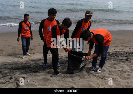 Lhokseumawe, Aceh, Indonesien. 4 Nov, 2018. Freiwillige gesehen mit einem Plastikbeutel bis Müll am Strand abzuholen. Indonesischen Freiwilligen aus BNPB (Nationale Behörde für Katastrophenmanagement) einen Strand aufräumen und auch gepflanzt 3000 Bäume eine saubere Umwelt für alle in Lhokseumawe Stadt zu erstellen. Credit: Maskur hat/SOPA Images/ZUMA Draht/Alamy leben Nachrichten Stockfoto