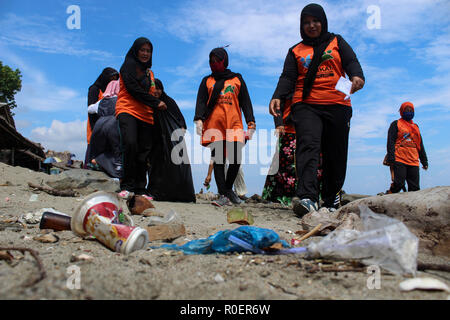 Lhokseumawe, Aceh, Indonesien. 4 Nov, 2018. Freiwillige gesehen mit einem Plastikbeutel bis Müll am Strand abzuholen. Indonesischen Freiwilligen aus BNPB (Nationale Behörde für Katastrophenmanagement) einen Strand aufräumen und auch gepflanzt 3000 Bäume eine saubere Umwelt für alle in Lhokseumawe Stadt zu erstellen. Credit: Maskur hat/SOPA Images/ZUMA Draht/Alamy leben Nachrichten Stockfoto