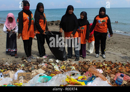 Lhokseumawe, Aceh, Indonesien. 4 Nov, 2018. Freiwillige gesehen mit einem Plastikbeutel bis Müll am Strand abzuholen. Indonesischen Freiwilligen aus BNPB (Nationale Behörde für Katastrophenmanagement) einen Strand aufräumen und auch gepflanzt 3000 Bäume eine saubere Umwelt für alle in Lhokseumawe Stadt zu erstellen. Credit: Maskur hat/SOPA Images/ZUMA Draht/Alamy leben Nachrichten Stockfoto