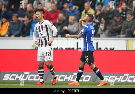 Bielefeld, Deutschland. 04 Nov, 2018. 2. Fussball Bundesliga, Arminia Bielefeld - FC St. Pauli, 12. Spieltag in der Schüco Arena. Der Bielefelder Torschütze Keanu Staude (r) feiert sein Tor zum 1:0. Ryo Miyaichi (l) aus Hamburg schaut enttäuscht. Credit: Friso Gentsch/dpa - WICHTIGER HINWEIS: In Übereinstimmung mit den Anforderungen der DFL Deutsche Fußball Liga oder der DFB Deutscher Fußball-Bund ist es untersagt, zu verwenden oder verwendet Fotos im Stadion und/oder das Spiel in Form von Bildern und/oder Videos - wie Foto Sequenzen getroffen haben./dpa/Alamy leben Nachrichten Stockfoto