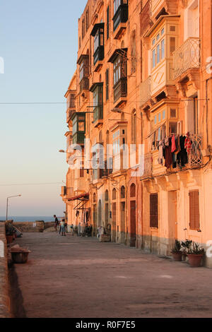 Valletta, Malta - Mai 2018: Real Life auf Valletta Straße in orange Sonnenuntergang - Kleidung trocknen auf typische maltesische Balkon Stockfoto